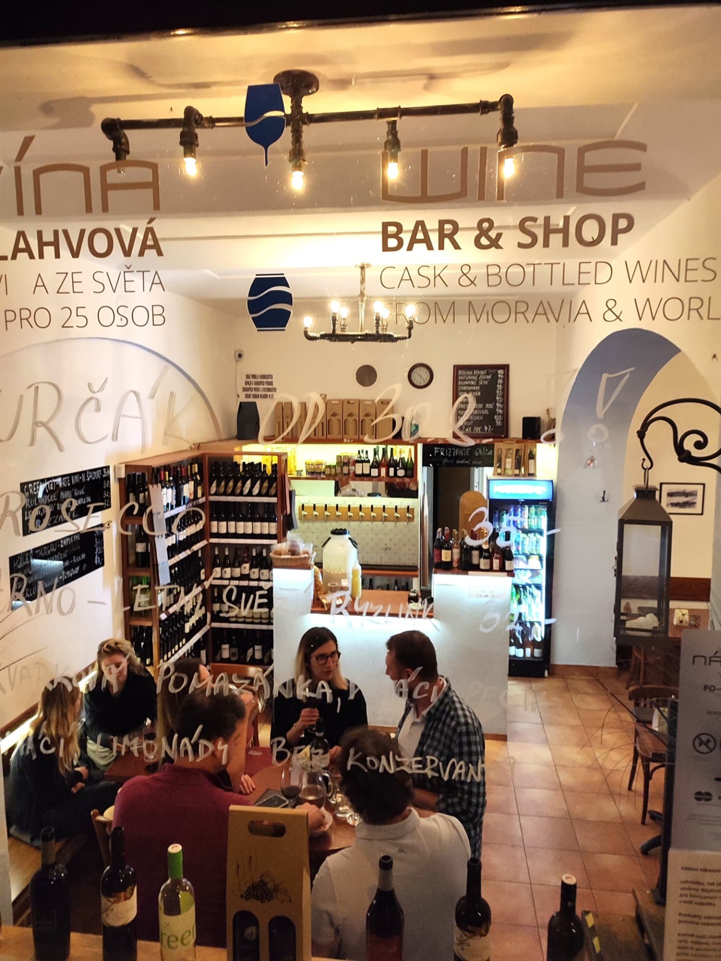 Bar vinárny Náplavní s pípami na stáčená vína a policemi lahví